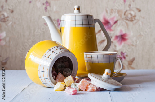 Multicolored oriental sweets, Turkish delight and coffee in yellow vintage old cup, still life photo