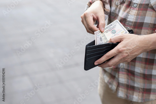 Businessman Person holding an wallet in the hands of an man take money out of pocket.
