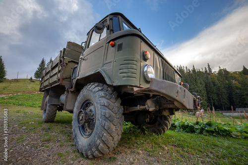 Old all terrain truck with big protector rubber tires for off road use.