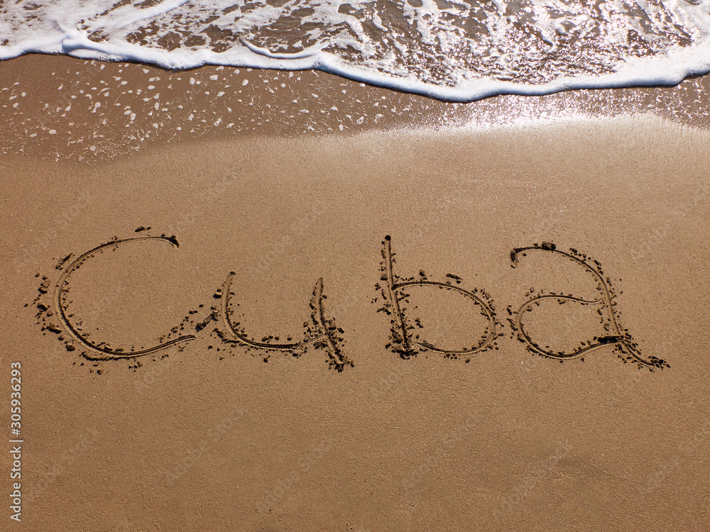 Fototapeta premium Inscription Cuba on the sandy beach and foamy sea water