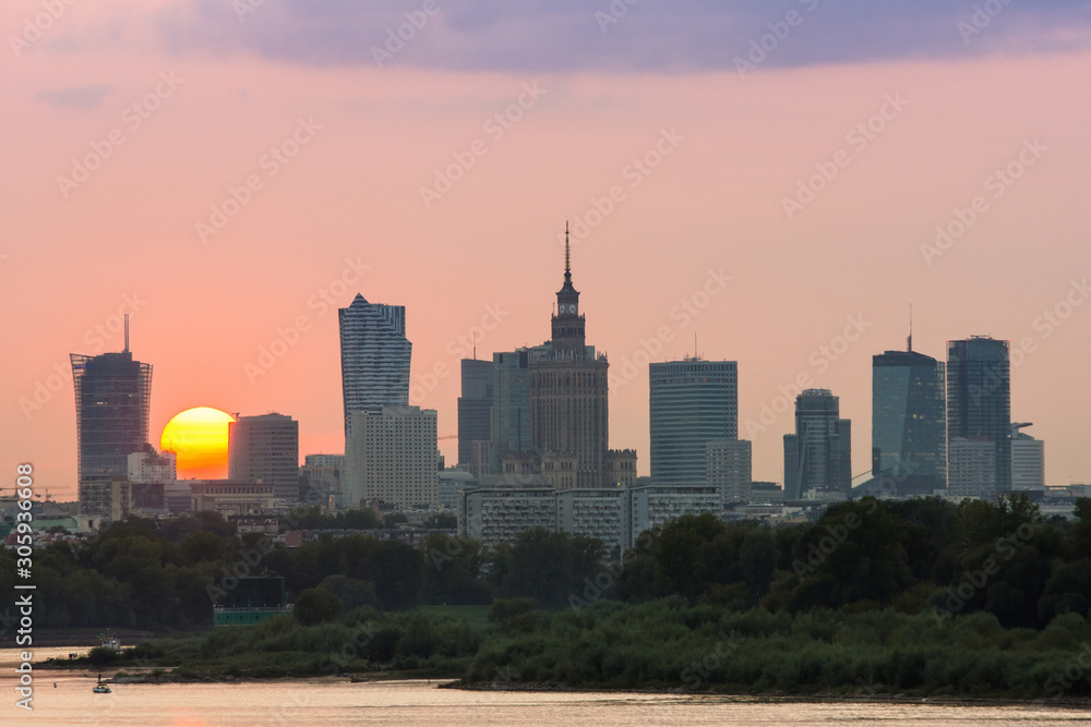 Panorama wieżowców w Warszawie podczas kolorowego zachodu słońca, odbicie w Wiśle, Polska