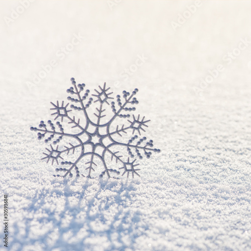 Winter square background with beautiful silver snowflake on whiteness snow surface. Merry Christmas and Happy New year greeting cards concept. © EMrpize