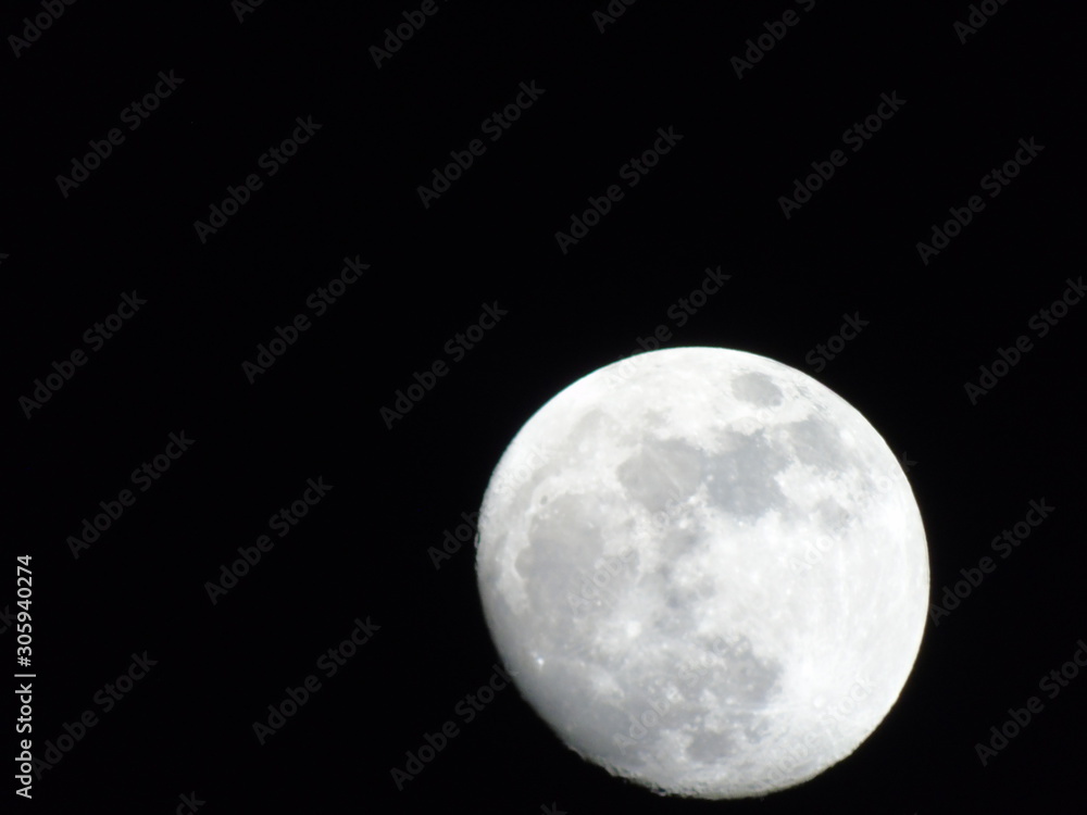 Obraz premium Beautiful caption of the moonlight over the village in winter days with some trees and leaves in the background by night and by day.