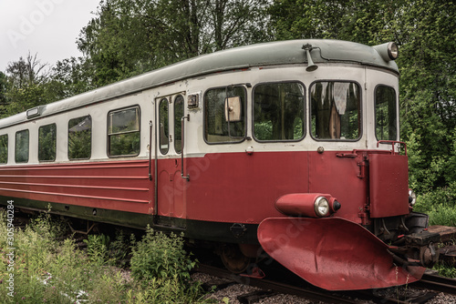 Old abandoned rail bus standing on an overgrown track