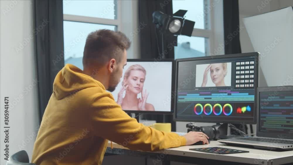 Freelance videographer colorist editing footage using professional