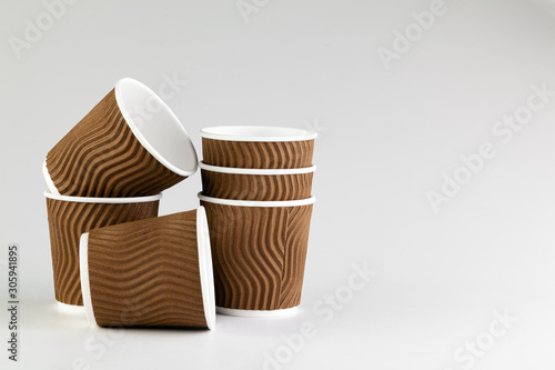Disposable paper cup of coffee on grey background . Package for drinks.