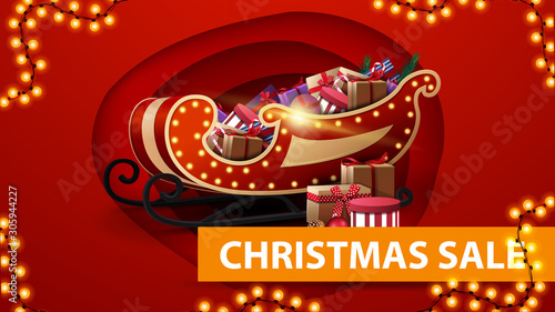 Christmas sale, red discount banner in paper cut style, garland and Santa Sleigh with presents