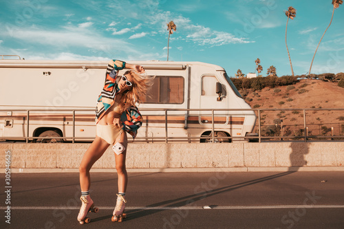 retro style skater girl with a camper van in the background. california lifestyle