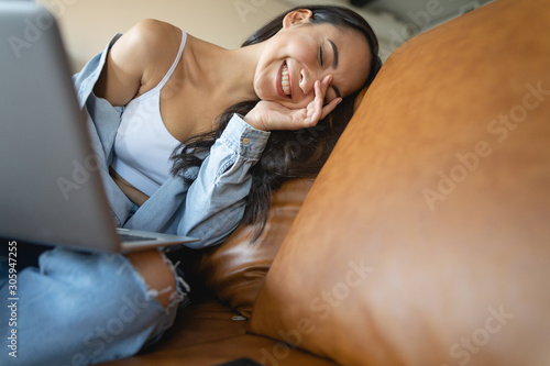 Cheerful young woman enjoying her online communication