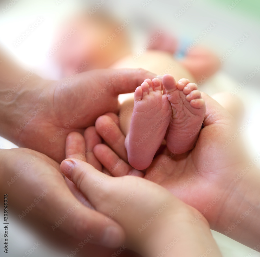Infant heels in mother's and fathers hands Infant heels in mother's and fathers hands