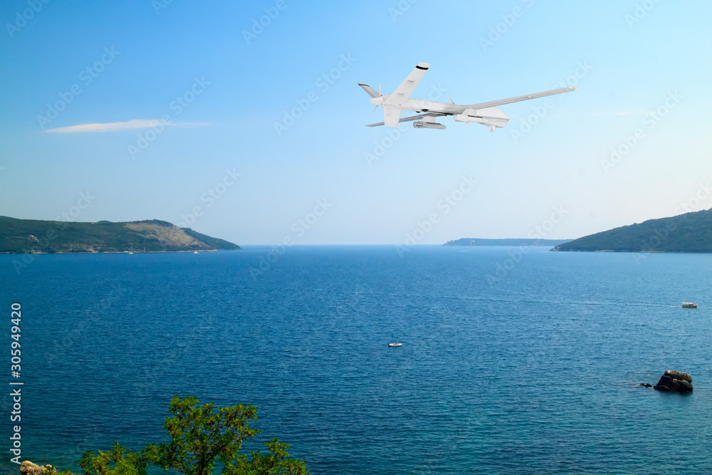 unmanned RC military drone flies over calm sea with beautiful white clouds on blue sky