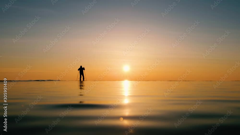 Skater on ice Lake Baikal at sunrise or sunset in winter. Silhouette Skater on ice Lake Baikal at sunrise or sunset in winter. Silhouette