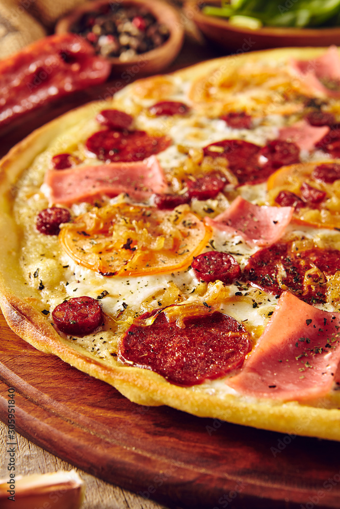 Meat and tomato pizza on wooden table close up Meat and tomato pizza on wooden table close up