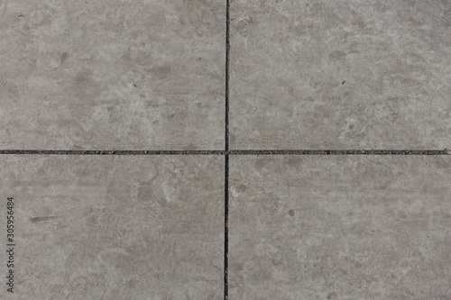 Crossed joints between light grey concrete slabs