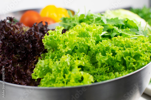 Salad leaves in metal bowl close-up ready for cooking