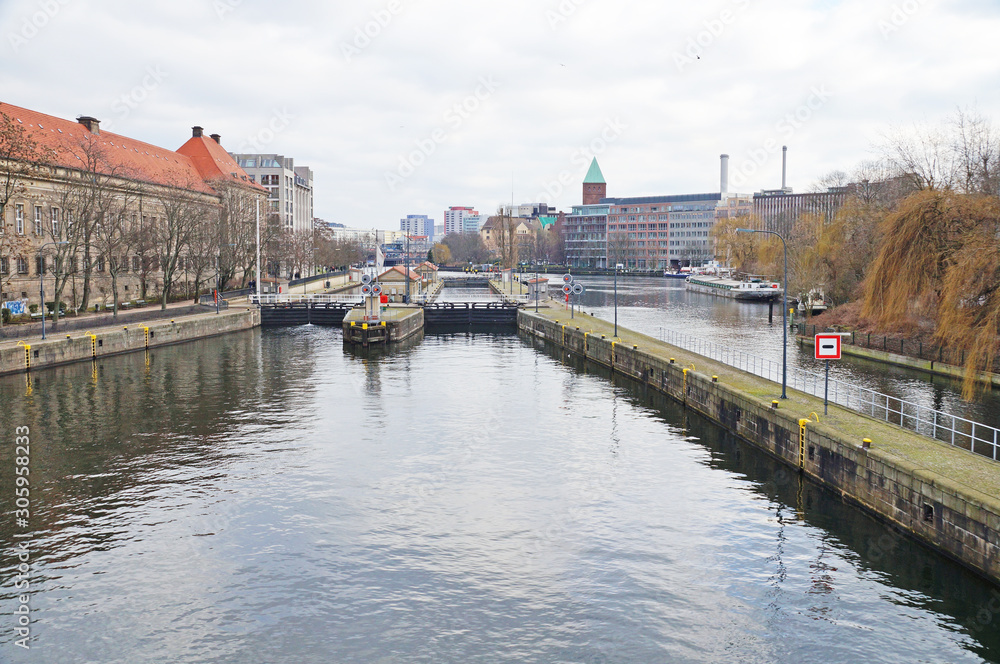 A ship is sailing along a river in the center of Berlin. City landscape. City river transport.