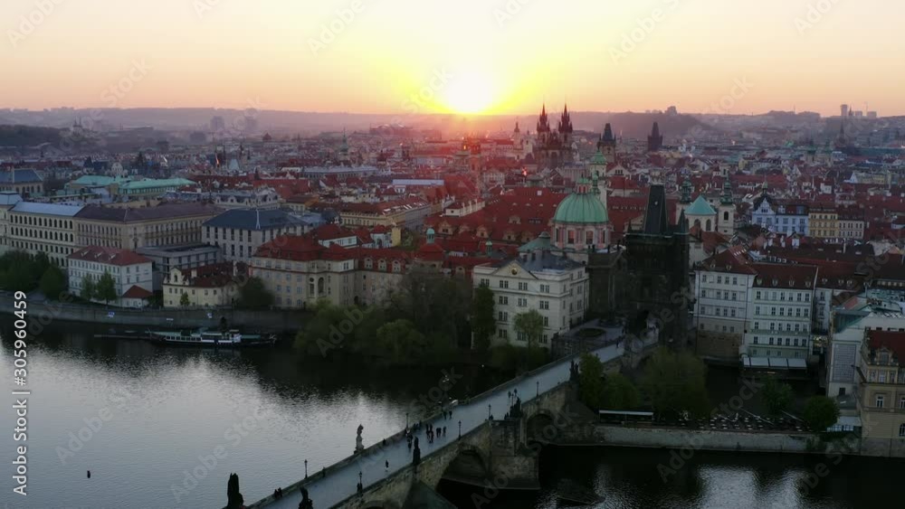 Aerial view downtown Prague and Charles bridge at sunrise. Picturesque cityscape from high, drone moving above water of Vltava river and buildings on embankment flying backwards from Charles bridge Aerial view downtown Prague and Charles bridge at sunrise. Picturesque cityscape from high, drone moving above water of Vltava river and buildings on embankment flying backwards from Charles bridge