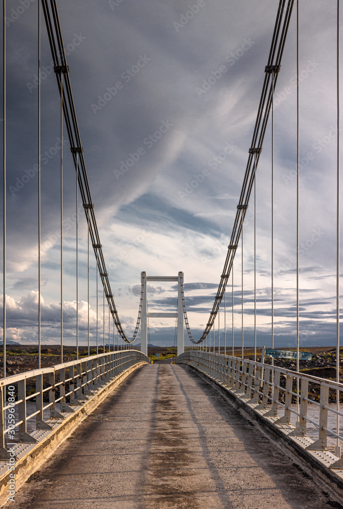Dramatic empty road cable bridge, suspension bridge cloudy sky by sunset,