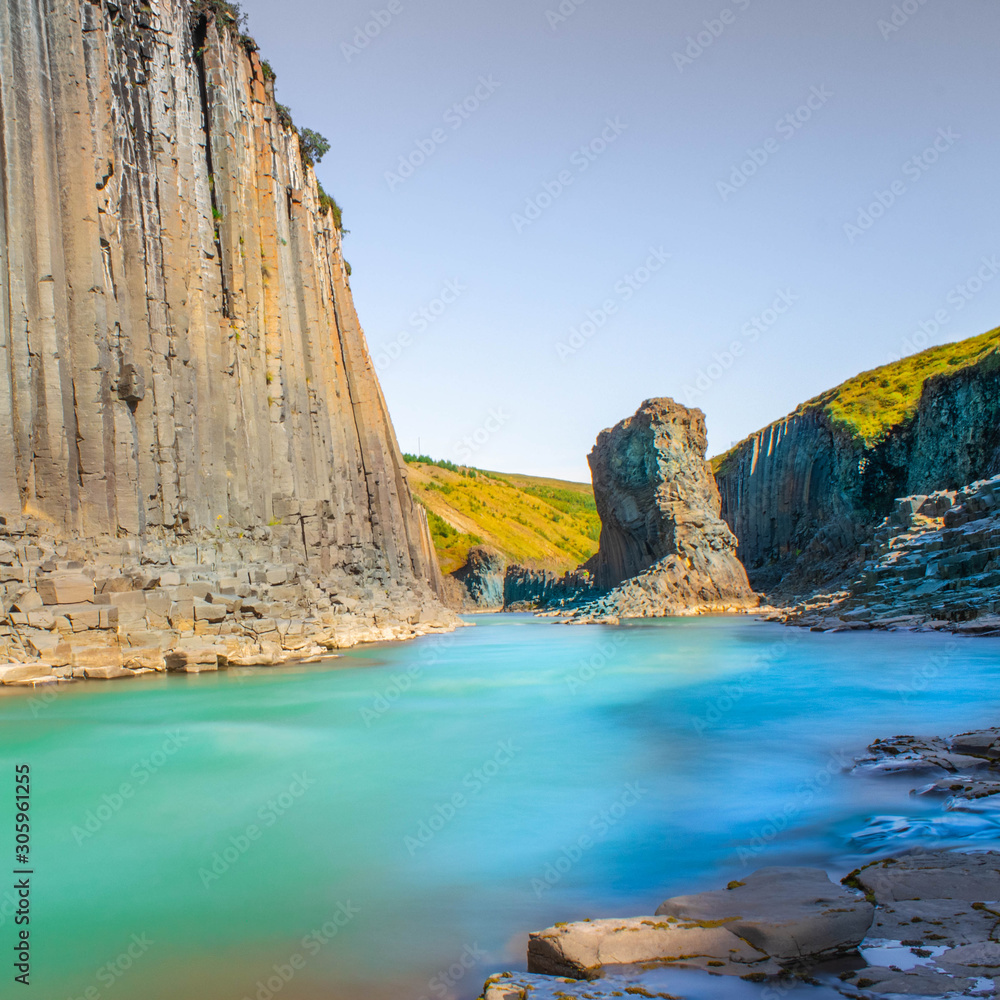 Basalt column canyon with clean glacial river with turquoise and cyan water, Iceland Studlagil Canyon