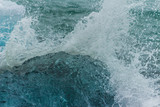 Wave water splash crushing into clear iceberg on the beach Antarctice