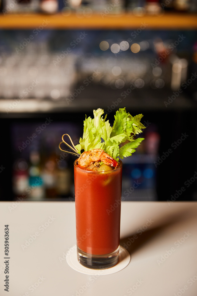 bloody mary cocktail with celery and shrimp in glass on bar counter bloody mary cocktail with celery and shrimp in glass on bar counter