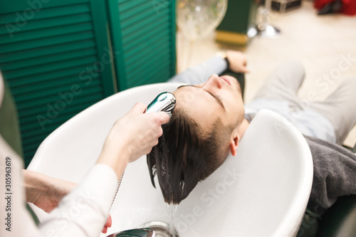 Hairdresser washes a client’s hair before cutting