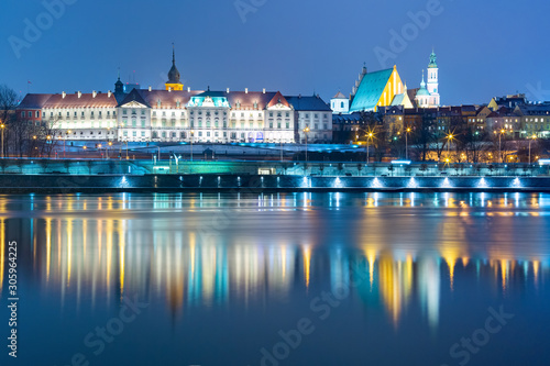 Old Town with reflection in the Vistula River during evening blue hour, Warsaw, Poland.