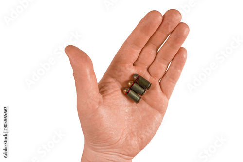 Man hand holds three bullets on an open palm. Isolated closeup on white background. Concept of crime investigation, ballistics or arms and gun shop. Clue proof in expert hand