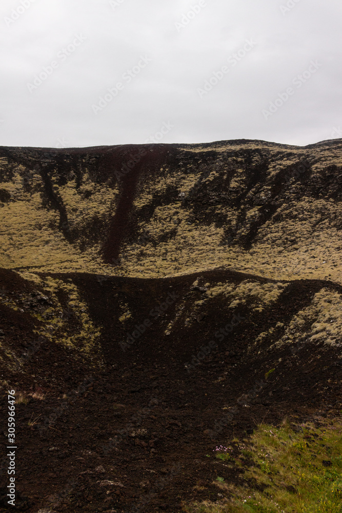 Inactive volcano crater, black gravel sand dunes covered in moss, Iceland