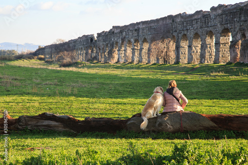 a woman and her dog, spectators of the great Appio Claudio aqueduct photo