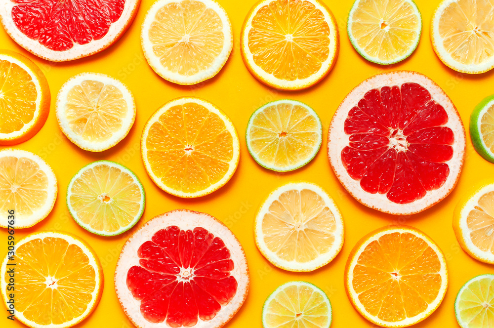 Flat lay composition with slices of fresh lemon orange grapefruit lime on yellow background top view. Citrus Juice Concept, Vitamin C, Fruits. Creative summer background. Close-up fruit pattern Flat lay composition with slices of fresh lemon orange grapefruit lime on yellow background top view. Citrus Juice Concept, Vitamin C, Fruits. Creative summer background. Close-up fruit pattern
