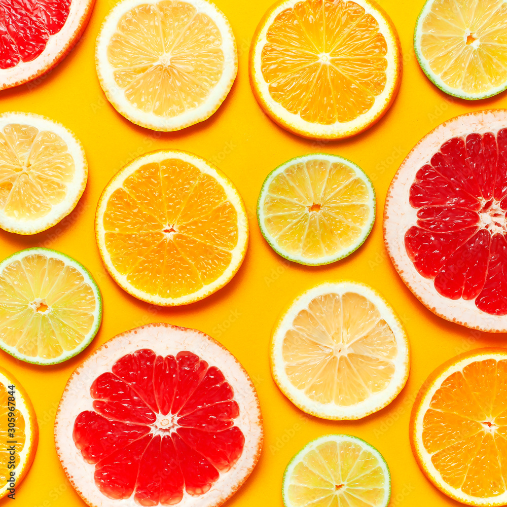 Flat lay composition with slices of fresh lemon orange grapefruit lime on yellow background top view. Citrus Juice Concept, Vitamin C, Fruits. Creative summer background. Close-up fruit pattern