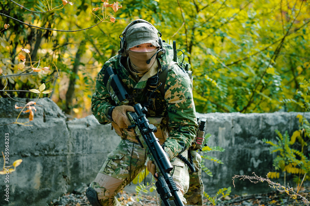 Closeup airsoft man in uniform hold sniper rifle on green forest background  foto de Stock | Adobe Stock
