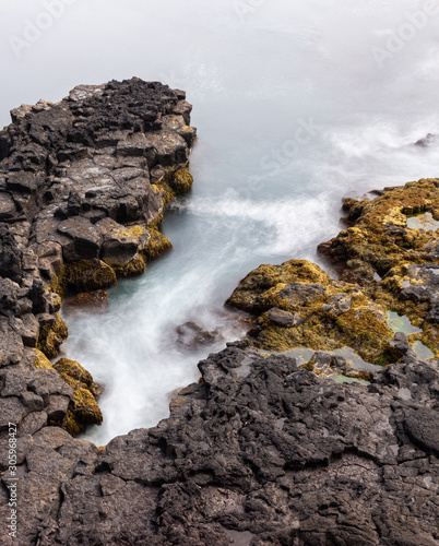 waves crashing on rocks, rocky coastline, coast of Iceland long exposure