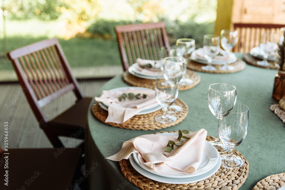 Festive table with green tablecloth decorated with flowers and candles Festive table with green tablecloth decorated with flowers and candles