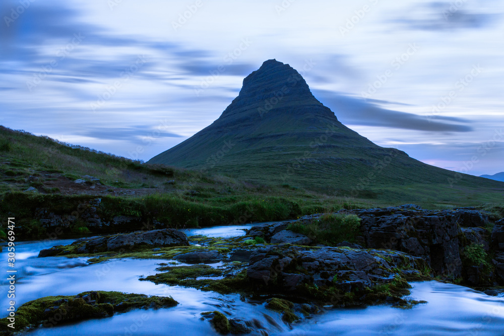 Small creek flowing in high mountains, stream in the evening, Kirkjufell Iceland
