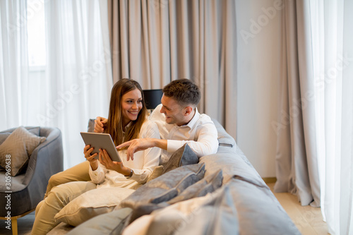 Lovely young couple with digital tablet in the room