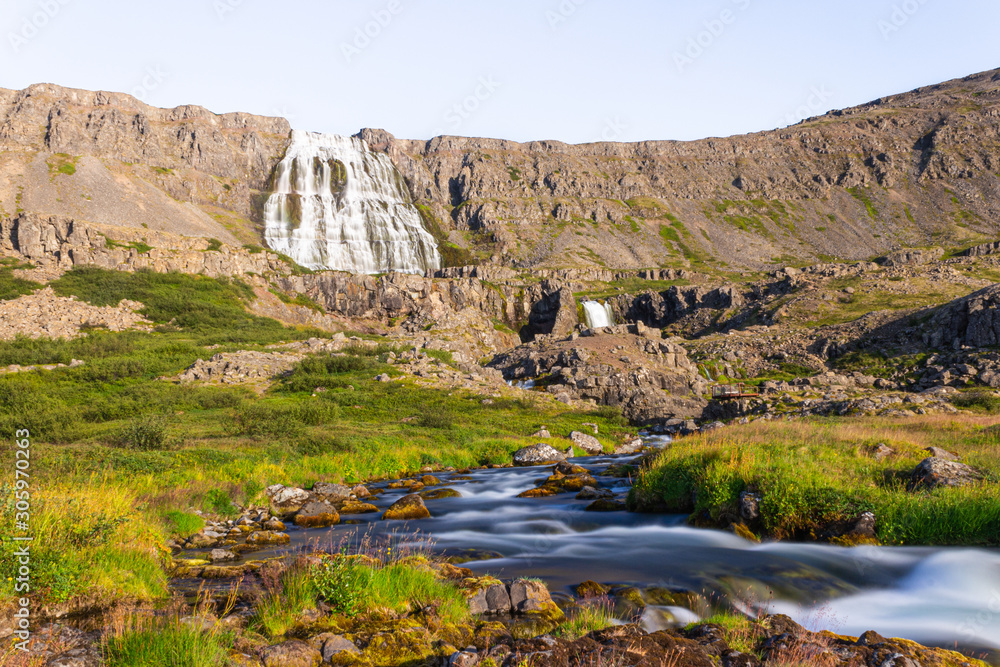 Giant waterfall in the mountains, high massive rocky mountains and river, Dynjandi Iceland