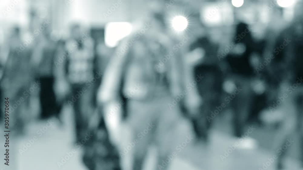 Many people walk inside the mall exhibition store. Blurred Background Many people walk inside the mall exhibition store. Blurred Background