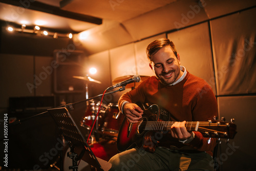 Portrait of cheerful man playing guitar.