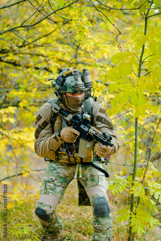 Airsoft man in uniform, move with machine gun on yellow forest backdrop. Vertical photo Airsoft man in uniform, move with machine gun on yellow forest backdrop. Vertical photo