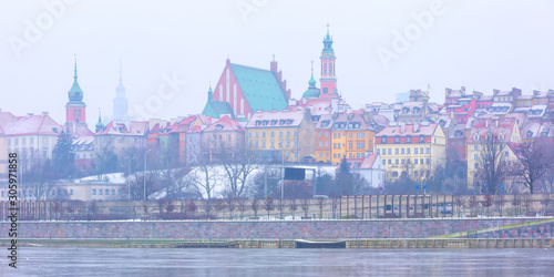 Panorama of Royal Castle and colorful houses by the Vistula River in Warsaw, Poland.