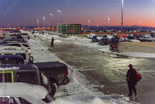 Back view passengers walking with luggage at terminal parking of Denver International Airport (DIA) photo