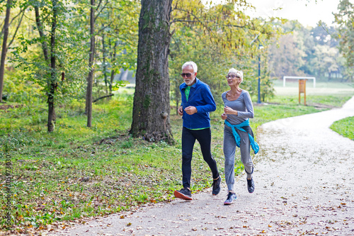 Mature couple man and woman jogging in the park