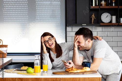 couple in kitchen at breakfast smile