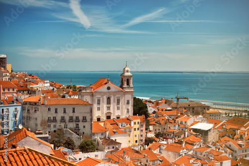 Photo Panoramic view on the roofs of Lisbon from Alfama in the summer time with blue sky and river on background