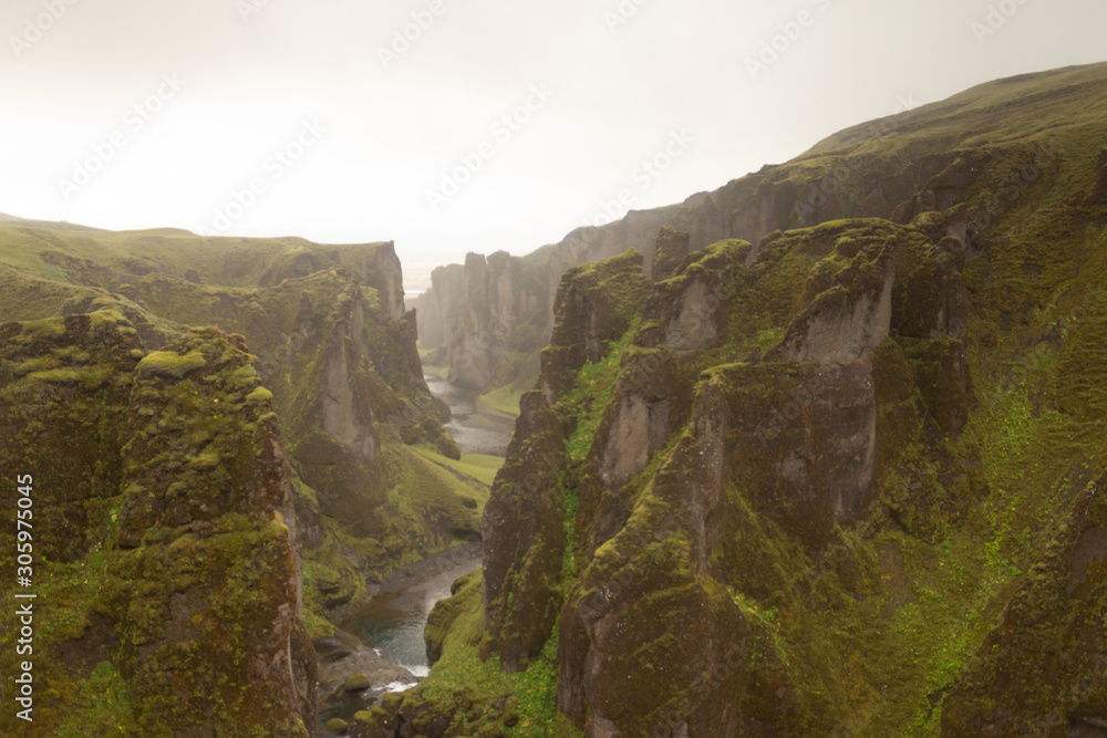 Beautiful moss stone canyon in fog, dramatic clouds, and river on the bottom