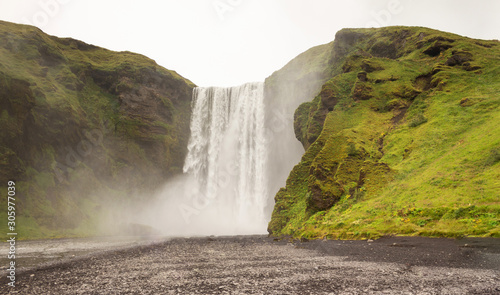 Large mighty waterfall in mountains, wide waterfall Iceland - Skógafoss without people