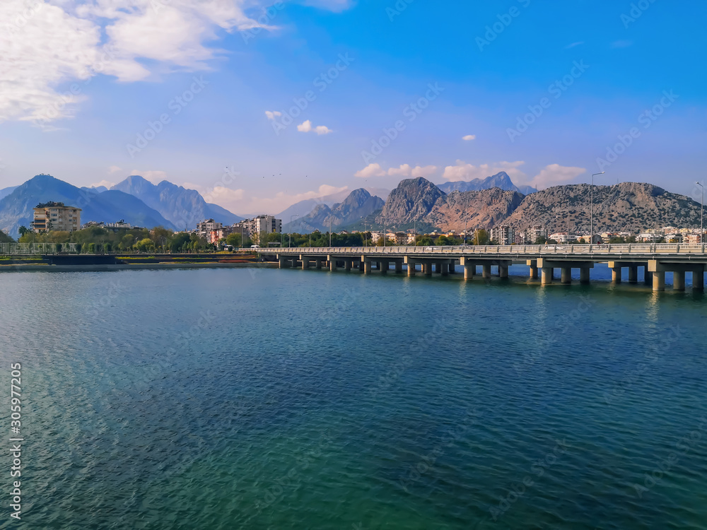 Bridge over the Boga Stream River on Ataturk Boulevard in Antalya and the Taurus Mountains on the horizon. Amazing cityscape of the Turkish resort, beautiful panorama of the city