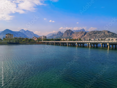 Bridge over the Boga Stream River on Ataturk Boulevard in Antalya and the Taurus Mountains on the horizon. Amazing cityscape of the Turkish resort, beautiful panorama of the city